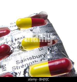 blaue, rote und gelbe Grippe Kapseln auf weißem Hintergrund Stockfoto