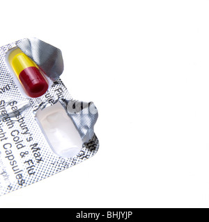blaue, rote und gelbe Grippe Kapseln auf weißem Hintergrund Stockfoto