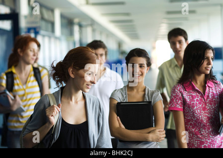 Schülerinnen und Schüler zu Fuß entlang der Schule Flur zusammen Stockfoto