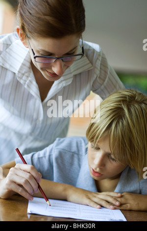 Junior high Schüler Lehrer anzusehen korrigiert Klassenarbeiten Stockfoto