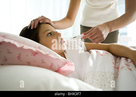 Mutter Überprüfung Tochter Temperatur, Stirn streicheln Stockfoto