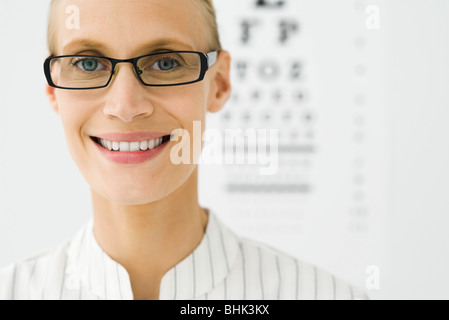 Junge Frau mit Brille, Sehtafel im Hintergrund, Porträt Stockfoto