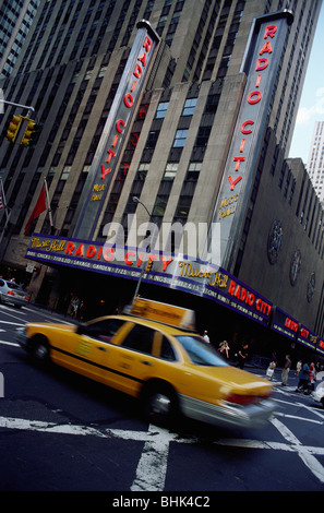 Manhattan, New York, USA. Gelbes Taxi fahren vorbei an der Radio City Music Hall. Stockfoto