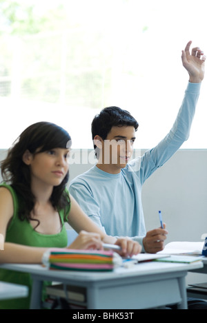 Schülerinnen und Schüler in der Klasse, teenboy, die Hand heben Stockfoto