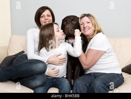 Schuss von drei Generationen einer Familie lachen mit ihrem Hund Stockfoto