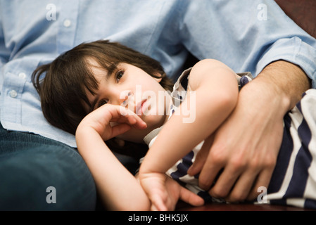 Kleiner Junge mit Kopf in des Vaters Schoß ruhen Stockfoto