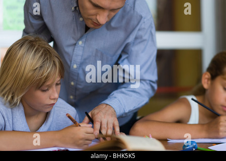 Lehrer helfen Grundschule Schüler in der Klasse Stockfoto
