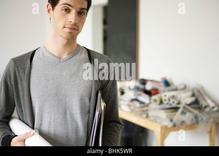 Mann trägt aufgerollt Bauplan unter arm Stockfoto