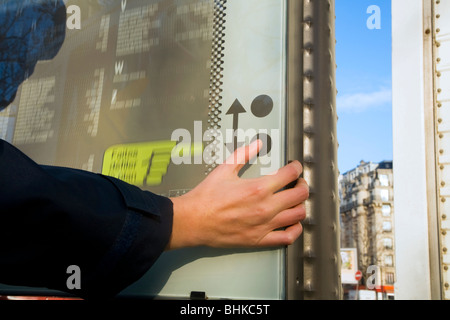 Person betrachten und mit Push-Button eine interaktive touristische Betrieb / verschieben / Informationen / Straße Karte von Paris. Frankreich. Stockfoto