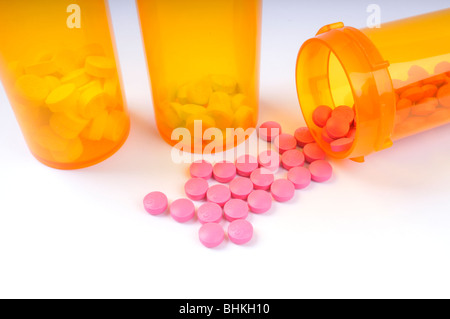 Flasche rosa Rezept Amitriptylin Pillen umgekippt mit 2 zusätzlichen Flaschen Pillen auf weißem Hintergrund. Stockfoto