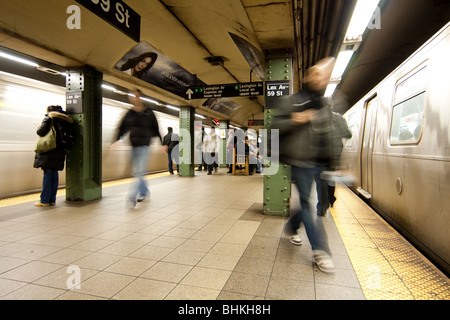 Pendler Passagiere warten und Wandern in u-Bahn Bahnhof Plattform, während Zug Wagen während der Hauptverkehrszeit anreisen. Stockfoto