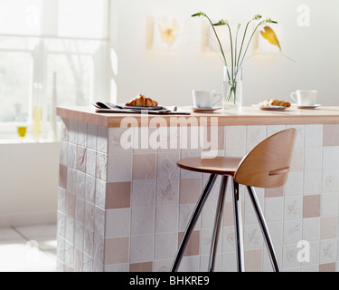 Chrom + Holz Hocker an der Theke auf gefliesten Halbinsel Einheit in Wirtschaft-Küche Stockfoto