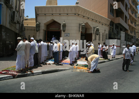 Aufruf zum Gebet in Dubai. Hunderte von Männern, die in den Straßen außerhalb verpackt Moscheen beten. Stockfoto