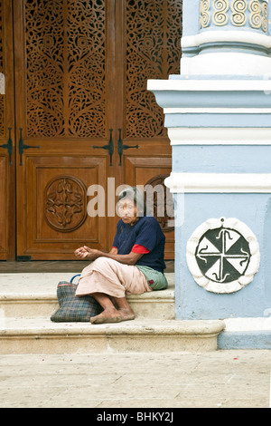 alten barfuß mexikanische indigene indische Frau tragen schmutzige blauen Pullover betteln am Eingang zum Templo de Santo Domingo Ocotlan Stockfoto