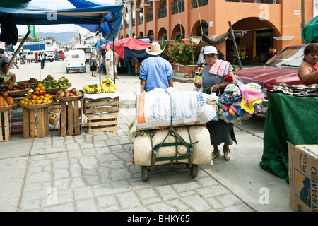 zwei schwer beladenen Hausierer squeeze von einander am Eingang zum Ocotlan Markt Bundesstaat Oaxaca Mexico Stockfoto