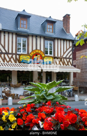 Beuvron-En-Auge, Normandie, Frankreich. Fachwerk-Lebensmittelmarkt in der wichtigsten Straßen, bunten Blumen im Vordergrund. Stockfoto