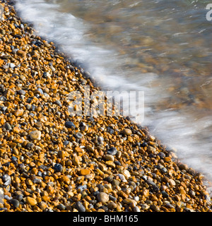 Hastings, East Sussex, England. Sonnendurchflutetes Kiesel von der Flut umspült. Stockfoto