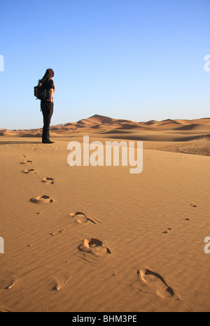 Weibliche Touristen blickt auf den Erg Chebbi Sanddünen in der Sahara-Wüste in der Nähe von Merzouga, Marokko, Nordafrika Stockfoto