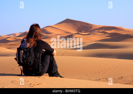 Einsame weibliche Touristen blickt auf den Erg Chebbi Snad Dünen der Sahara-Wüste in der Nähe von Merzouga, Marokko Stockfoto