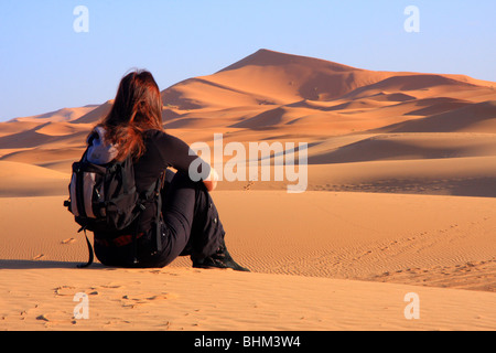Einsame weibliche Touristen blickt auf den Erg Chebbi Snad Dünen der Sahara-Wüste in der Nähe von Merzouga, Marokko Stockfoto