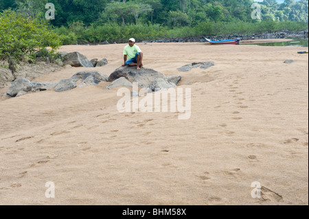 Neville Moses, Macushi, ruht auf Felsen Essequibo River Iwokrama Rainforest Guayana Schild Guyana in Südamerika Oktober Stockfoto