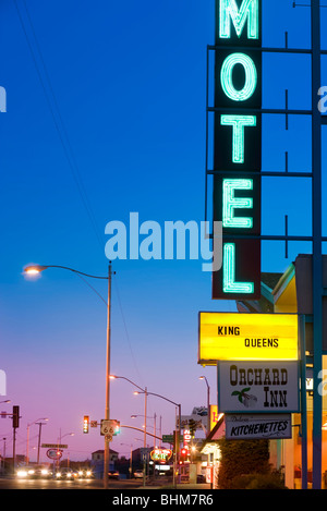 Neon-Motel-Schild am Orchard Inn in Kingman Arizona entlang der historischen uns Route 66. Route 66 Schild vorne. In der Abenddämmerung. Stockfoto