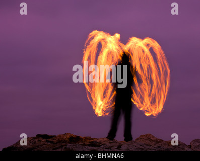 Mann Feuer drehen (Feuer-Poi) auf Cornish Prachtnelke, Godrevy, Cornwall, England. Herbst (Oktober) 2009 Stockfoto