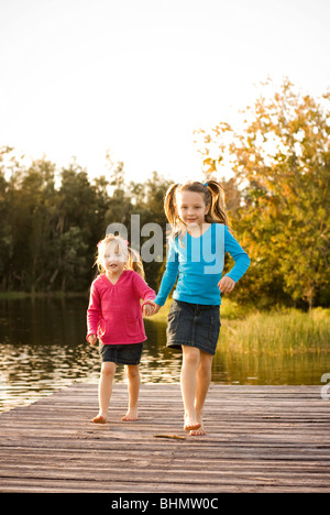 dock-Schwestern spielen auf See Stockfoto