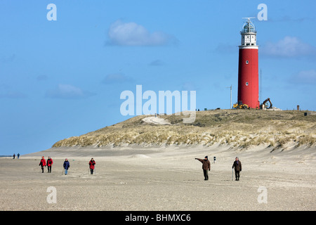 Spaziergänger am Strand und Leuchtturm am Cocksdorp, Texel, Niederlande Stockfoto