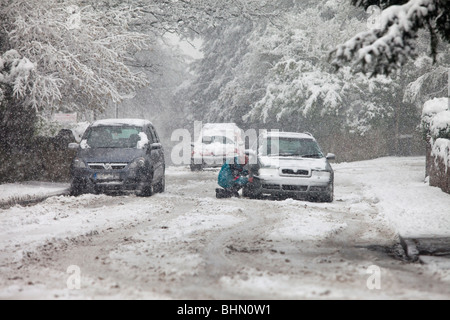 Autos stecken im Schnee auf einer Nebenstraße in Malvern, Großbritannien Stockfoto