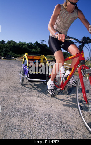 Frau Reiten Fahrrad ziehen Kind. Stockfoto