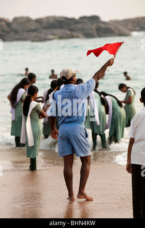 Indien, Kerala, Kovalam, Hawah (Eve) Strand, Bademeister, die rote Fahne winkt Badegäste in Gefahr Stockfoto