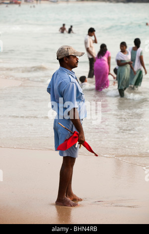 Hawah (Eve) Strand, Bademeister indische Badegäste im Meer beobachten, Kovalam, Kerala, Indien Stockfoto