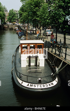 Holländischen Schiff festgemacht an einem Kanal neben einer von Bäumen gesäumten Straße, Amsterdam, Holland Stockfoto