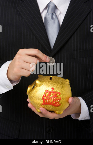 Geschäftsmann mit Sparschwein Stockfoto