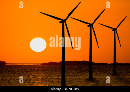 Silhouette der drei off Shore Windkraftanlagen im Sonnenaufgang Stockfoto