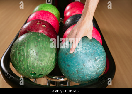 Bowling-Kugel in Spieler Mann hand in bunten Reihen Stockfoto