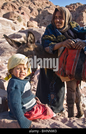 Frau und ihre Tochter, ruhen Sie sich nach einer langen Fahrt auf einem Esel, Petra, Jordanien, Asien. Stockfoto