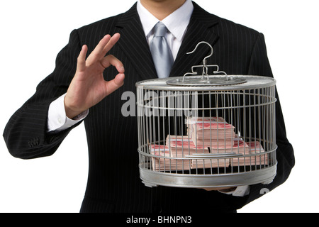 Geschäftsmann hält Vogelkäfig mit Geld gefüllt Stockfoto