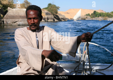 Nubische Feluke Kapitän Lenkung Clearing von Elephantine Island in Assuan, Ägypten Stockfoto