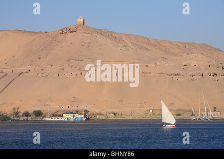 Feluke Segeln in den frühen Morgenstunden auf dem Nil vorbei die Gräber der Adligen in Assuan, Ägypten Stockfoto