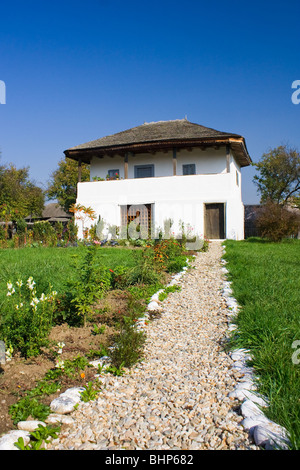 Ein altes Haus mit einer langen gepflasterten Fahrt vor Stockfoto