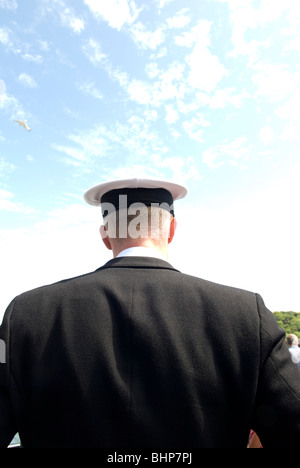 Heckansicht des jungen Marineoffizier in Uniform mit blauer Himmel und Möwe im Himmel Stockfoto