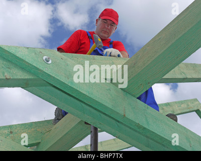 Tischler, fahren einen Nagel in Haus Sparren Rahmung Strahl Stockfoto