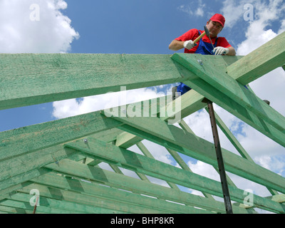 Tischler, fahren einen Nagel in Haus Sparren Rahmung Strahl Stockfoto