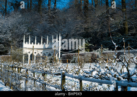 Espaliered Obstbäume und die Exedra im Painswick Rokoko Garden in The Cotswolds im Schnee im Februar Stockfoto