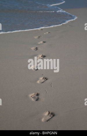 Schritte in den Strandsand wird von der Flut weggespült Stockfoto