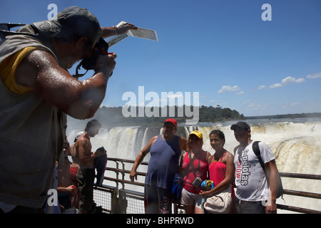 Tour in Gruppe posiert für Fotos auf dem Gehweg über die Devils throat Garganta del diablo Iguazu national park Argentinien Stockfoto