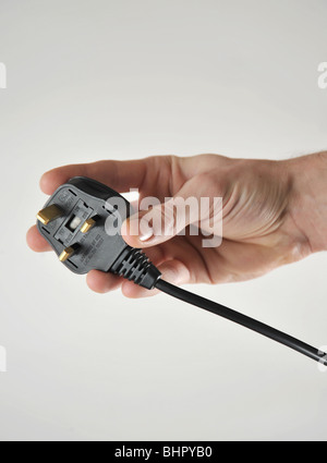 UK-Stil 3-Pin-Stecker in eine Hand gehalten, als ob Sie in ein 240V Steckdose Strom-Steckdose stecken Stockfoto