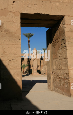 Anzeigen der Tempel von Ramses III an der Statue von Ramses II am ersten Hof der Karnak-Tempel in Luxor, Ägypten Stockfoto